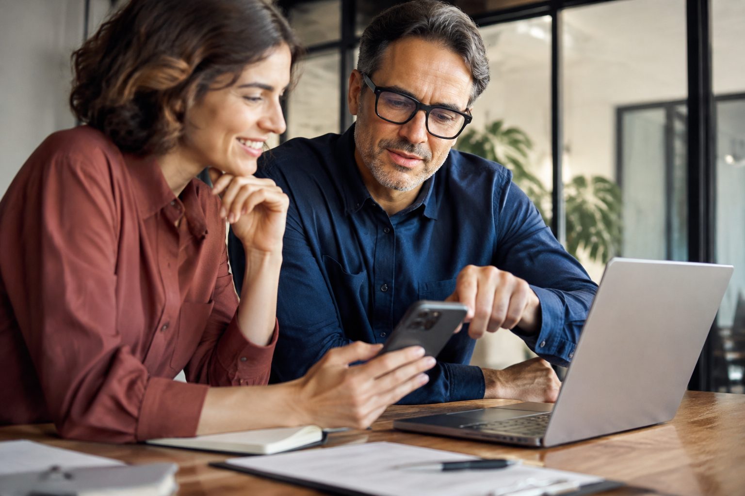Business owner and web professional reviewing a website's mobile contact path before launch
